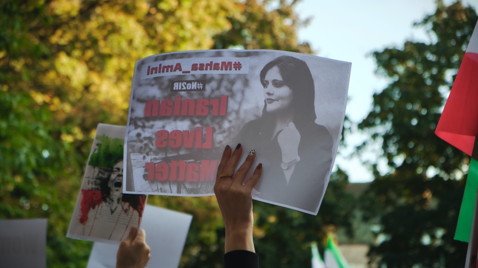 Protestschild mit dem Foto von Jina Mahsa Amini