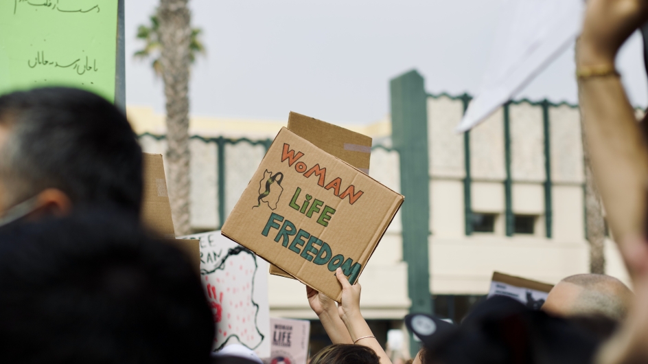 Protestschild mit dem Text "Woman, Life, Freedom"