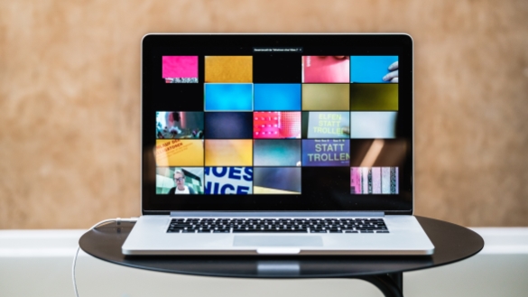 Aufgeklappter Laptop mit Kacheln einer Videokonferenz "Elfen statt Trollen"