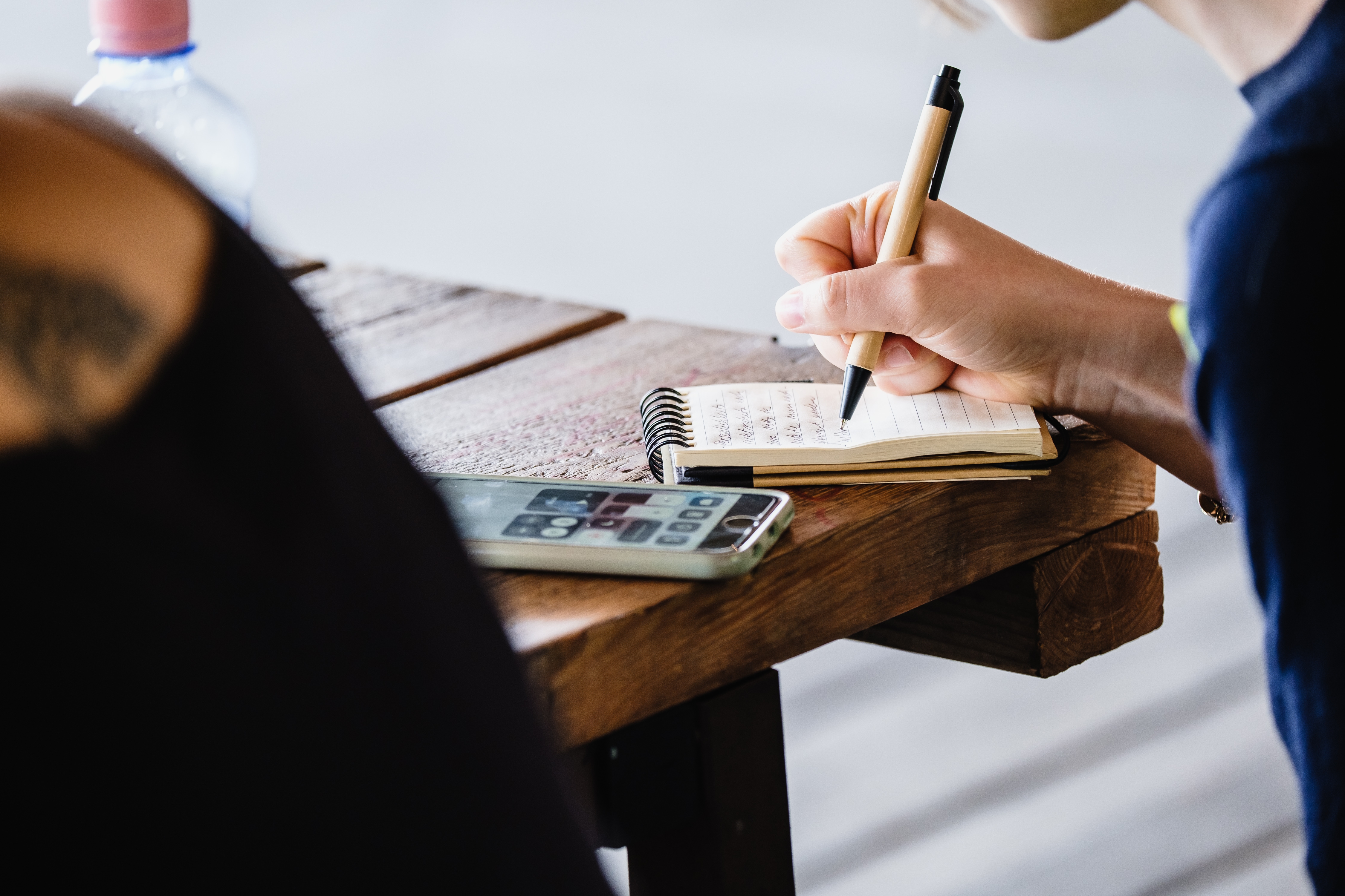 Notizen machen Handy, Block und eine Frau, die schreibt